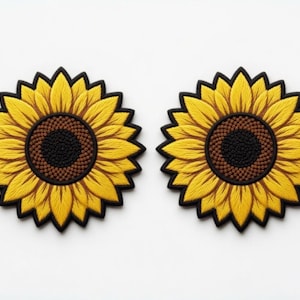Puede incluir: Dos parches bordados de girasoles. Cada parche presenta pétalos amarillos, un centro marrón y un borde negro. Los parches circulares tienen una apariencia detallada y texturizada, perfectos para añadir a ropa o accesorios.