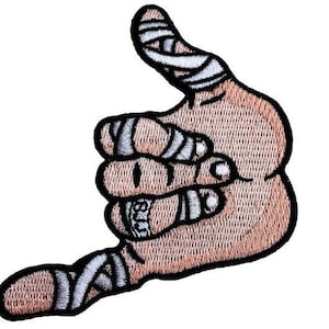 Peut inclure: Une main brune faisant le signe shaka, avec des bandages blancs enroulés autour des doigts.