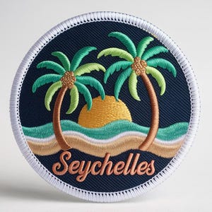 Peut inclure: Écusson brodé représentant une scène tropicale avec deux palmiers, un soleil couchant et des vagues océaniques. L'écusson est rond avec un fond bleu marine et le mot "Seychelles" en cursive.