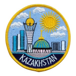 May include: Embroidered patch depicting a cityscape of Kazakhstan with a blue sky, white clouds, and a yellow sun. The patch includes the word "KAZAKHSTAN" in white lettering on a navy blue background.