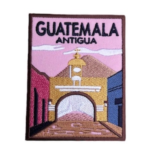 May include: Embroidered patch featuring a colorful illustration of a building with an archway in Antigua, Guatemala. The patch has a brown border and the text "GUATEMALA ANTIGUA" in black.