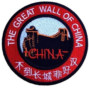 May include: A red and white embroidered patch with the text "The Great Wall of China" and a depiction of the Great Wall of China. The text "China" is also embroidered in red on the patch. The Chinese text "不到长城非好汉" is embroidered in white on the patch.
