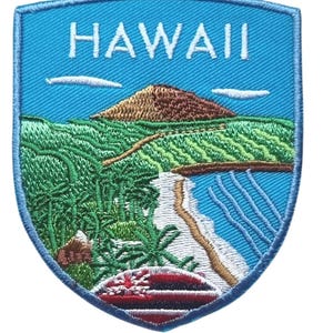 Puede incluir: Parche bordado con un paisaje hawaiano y la palabra "HAWAII". El parche muestra una montaña, palmeras y una playa con olas azules. La parte inferior del parche muestra la bandera hawaiana.