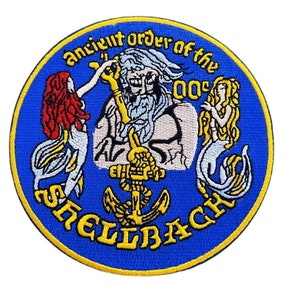 May include: A blue and yellow embroidered patch with the text "Ancient Order of the Shellback" and a depiction of a bearded man holding an anchor with two mermaids on either side.