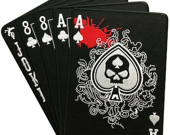 May include: A black felt patch with a white skull and spades design. The patch has a red blood splatter and the text "VELCRO PATCH". The patch features a joker, two 8s, and two aces.