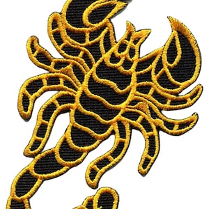 May include: Embroidered patch with a scorpion design. The patch features a black base with gold-coloured detailing. The scorpion is depicted with its claws raised and tail curved, with a detailed gold outline.