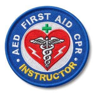 May include: A round, embroidered patch with a blue border and white text that reads "FIRST AID CPR AED INSTRUCTOR." The center features a red heart with a white caduceus symbol and a green cross.