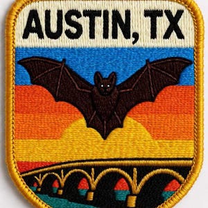Peut inclure: Écusson brodé représentant une chauve-souris aux ailes déployées au-dessus d'un pont, avec le texte "AUSTIN, TX". Le fond présente un dégradé de bleu, d'orange et de jaune. L'écusson a une bordure dorée.