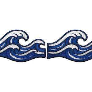 May include: Two embroidered patches in the shape of ocean waves. The waves are a deep blue with white detailing, creating a contrast. The patches are likely for decorative purposes, such as on clothing or bags.
