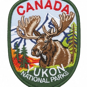 May include: An embroidered patch featuring a brown moose with large antlers in the foreground, set against a backdrop of blue mountains, green pine trees, and orange foliage. The text CANADA is in red at the top, and YUKON NATIONAL PARKS is in white at the bottom.