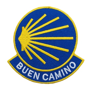 Peut inclure: Écusson brodé avec un cercle bleu et des rayons jaunes émanant d'une coquille jaune. Les mots "BUEN CAMINO" sont brodés en blanc sur une bannière bleue. Le patch a une bordure jaune.