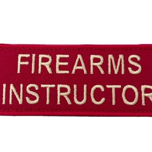 Könnte beinhalten: Roter rechteckiger Patch mit weiß gesticktem Text "FIREARMS INSTRUCTOR".