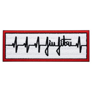 May include: Embroidered patch with a white background and a red border. The patch features a black heartbeat line design with the word "Jiu Jitsu" in a handwritten font. The design is centered on the patch.
