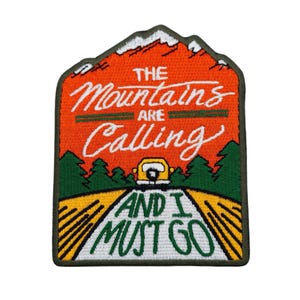 Op de afbeelding: Geborduurde patch met de tekst "The Mountains are Calling and I Must Go". De patch toont een gele auto op een weg, groene bomen en een bergketen met sneeuw. De patch heeft een donkergroene rand.