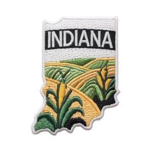 Peut inclure: Écusson brodé en forme de l'Indiana, avec le nom de l'État en blanc sur fond noir. La partie inférieure représente un champ de maïs dans des tons de vert, jaune et or, évoquant l'agriculture.