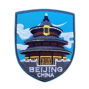 May include: Embroidered patch with a blue background featuring a gray and red temple with white clouds. The text "BEIJING CHINA" is written in white below the temple.