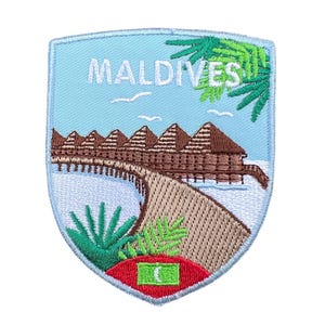 Può includere: Toppa ricamata con una vista delle Maldive. Il design include bungalow sull'acqua, palme e la parola "MALDIVES" in bianco su sfondo azzurro. La toppa ha la forma di uno scudo.