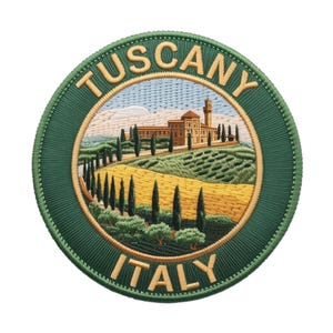 May include: Embroidered patch featuring a Tuscan landscape with rolling hills, cypress trees, and a building with a tower. The patch is round with a green border and the words "TUSCANY ITALY" in gold lettering.