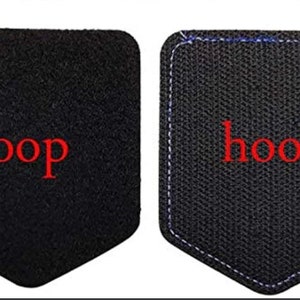 May include: Two black fabric patches with a hook and loop fastener system. The left patch has the word "loop" in red text. The right patch has the word "hook" in red text.
