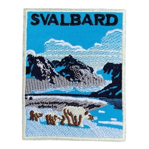 May include: Embroidered patch featuring a scenic landscape with the word "SVALBARD" in blue letters. The design includes mountains, a body of water, and polar bears. The patch has a light blue background and a white border.