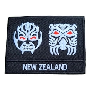 May include: Black embroidered patch with two white Maori tribal masks and the text "NEW ZEALAND" in white.