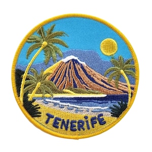 Könnte beinhalten: Gestickter Aufnäher mit einer tropischen Insel-Szene. Das Design zeigt einen Vulkan, Palmen, einen Strand und das Wort "TENERIFE" in Blau. Der Aufnäher hat einen blauen Hintergrund mit gelbem Rand und gelber Sonne.