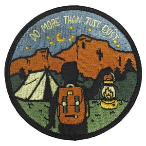 May include: Embroidered patch with a camping scene. A person with a backpack stands in front of a tent and a lantern. The text "Do More Than Just Exist" is stitched around the top of the patch.