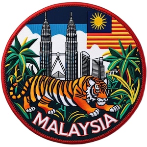 Op de afbeelding: Ronde patch met een tijger, palmbomen en de Petronas Towers. Het woord "MALAYSIA" staat in het wit. De achtergrond is blauw, groen en wit, met een rode rand. De Maleisische vlag is ook afgebeeld.