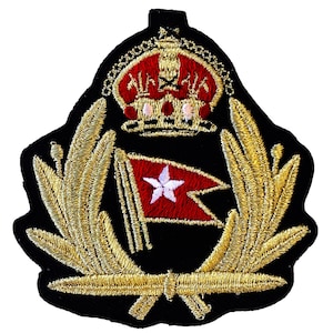 Könnte beinhalten: Gestickter Aufnäher mit roter und weißer Flagge, goldenem Lorbeerkranz und roter und goldener Krone auf schwarzem Hintergrund. Das Design deutet auf ein nautisches oder militärisches Thema hin.