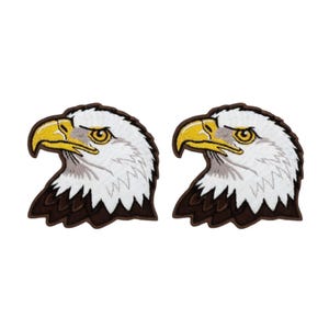 Op de afbeelding: Twee geborduurde patches met de kop van een Amerikaanse zeearend. De adelaar heeft een witte kop, gele snavel en bruine veren. De patches staan op een witte achtergrond.