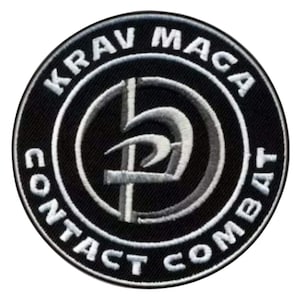 K&ouml;nnte beinhalten: Schwarzer und wei&szlig;er gestickter Aufn&auml;her mit den Worten "Krav Maga Contact Combat" in einem Kreis um ein stilisiertes "D" mit einem Schwert hindurch.