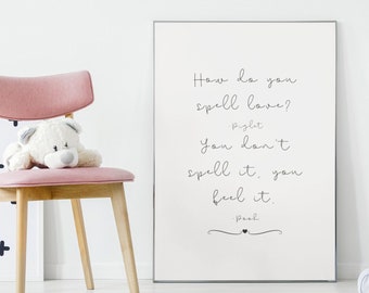 May include: A white framed print with a quote from Winnie the Pooh and Piglet that reads "How do you spell love? Piglet You don't spell it, you feel it. Pooh" The print is hanging on a white wall in a nursery with a pink chair and a white crib.