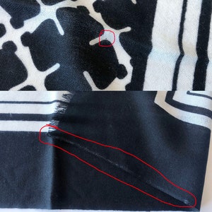 May include: Black and white patterned scarf. The top portion features a repeating pattern of black shapes on a white background. The bottom portion has black and white stripes and a fringed edge.