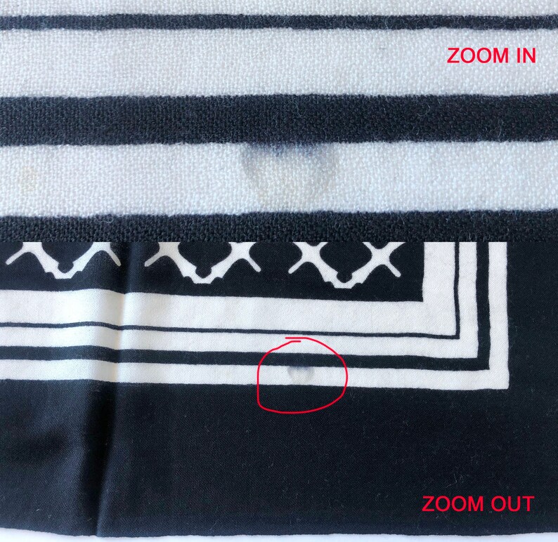 May include: A black and white patterned textile with horizontal stripes and a decorative border. The border features a geometric design. The words "ZOOM IN" and "ZOOM OUT" are visible in the image.