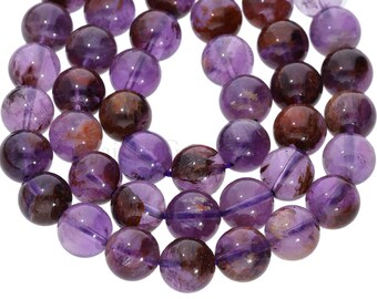 May include: A strand of round, purple amethyst beads with brown and gold inclusions. The beads are approximately 10mm in diameter.