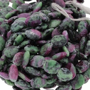 May include: A strand of green and pink oval-shaped gemstone beads. The beads are a mix of green and pink with black flecks.