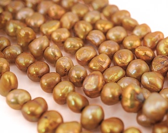 May include: A strand of golden brown freshwater pearls. The pearls are irregular in shape and have a slightly iridescent sheen.