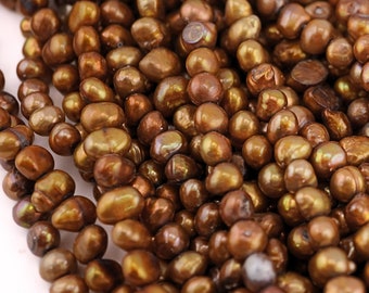 May include: A strand of brown freshwater pearls. The pearls are irregular in shape and have a slightly iridescent sheen.