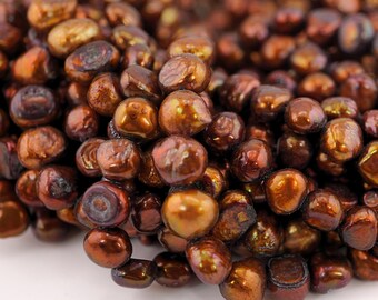 May include: A strand of brown freshwater pearls with a slightly iridescent sheen. The pearls are round and have a smooth, polished surface.