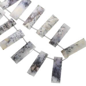 May include: A strand of white and gray agate gemstone beads, each bead is rectangular and has a unique pattern of black dendrite inclusions. The beads are strung on a silver wire.