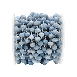 May include: A spool of blue gemstone beads with silver chain links. The beads are faceted and have a light blue color.