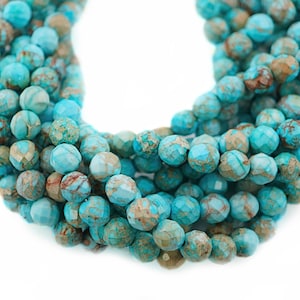 May include: A strand of turquoise blue gemstone beads with a faceted finish. The beads have a mottled brown and white pattern throughout.