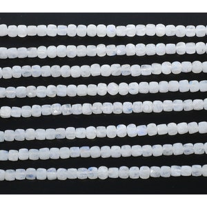 May include: A strand of white moonstone beads, each bead is faceted and has a square shape.