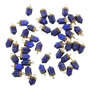 May include: A collection of 30 lapis lazuli gemstone pendants with gold-toned jump rings. The pendants are in the shape of a point or a teardrop.