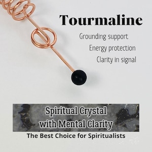May include: A copper-colored wire wrapped around a black sphere. The word "Tourmaline" is displayed above the text "Grounding support, Energy protection, Clarity in signal". Below is a banner that reads "Spiritual Crystal with Mental Clarity, The Best Choice for Spiritualists."