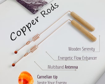 May include: Two copper rods with a coiled section and a carnelian tip. The rods are labeled "Copper Rods" and "Multiband Antenna". The rods are accompanied by two wooden rods labeled "Wooden Serenity" and "Energetic Flow Enhancer". The text "Carnelian tip Ignite Your Energy" is also included.