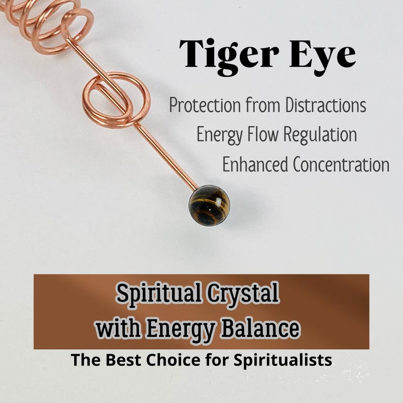 May include: A copper-colored wire wrapped into a spiral and a loop, with a small, round tiger eye stone at the end. Text reads "Tiger Eye" and describes benefits like "Protection from Distractions".