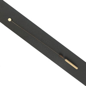 May include: A long, thin metal wire tool featuring a small, round, light-colored bead at one end. The opposite end includes a coiled metal spring section connected to a smooth, cylindrical, light-colored wooden handle for a secure grip.