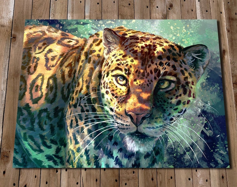 May include: A close-up of a jaguar's face, with a green and blue watercolor background. The jaguar's fur is a mix of brown, black, and yellow, with a white underbelly. The jaguar's eyes are green and its nose is pink.