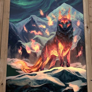 May include: A fiery wolf stands on a snowy mountain peak, surrounded by flames and a green aurora borealis in the sky. The wolf's fur is black with glowing orange flames emanating from its body.